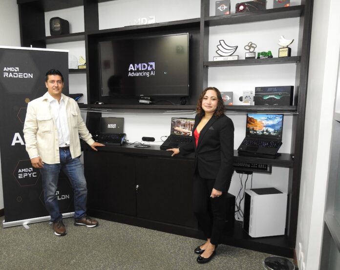 Alianza estratégica para impulsar la PC con IA para pymes. César Hernández de Lenovo y Gabriela Alvarado de AMD posando en el centro de experiencia junto a un mostrador de notebooks ThinkPad frente a una pantalla con el lema