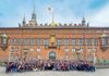 Convención CT 2026 navegará por Europa para fortalecer negocios y alianzas del canal TI Una gran fotografía grupal que reúne a decenas de distribuidores, fabricantes y directivos de CT Internacional posando sonrientes y saludando frente a la imponente fachada histórica de ladrillo rojo del Ayuntamiento de Copenhague. En la parte superior del edificio, ondea una bandera blanca con el logotipo de la empresa organizadora bajo un cielo parcialmente nublado.