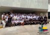 Congreso MyBusiness POS: XV años de un encuentro lleno de oportunidades Fotografía nocturna en plano general de un letrero monumental con letras tridimensionales iluminadas que forman la palabra "CARTAGENA" sobre una plataforma en la playa. Cada letra está decorada con pinturas artísticas y coloridas que muestran paisajes y rostros caribeños. En la esquina superior izquierda se superpone un logotipo cuadrangular blanco con una ilustración de una torre de reloj y una palma junto a la bandera de Colombia, detallando el texto "XV Congreso Anual de Punto de Venta - CARTAGENA | 28 AL 31 DE MAYO 2026 - MyBusiness POS".