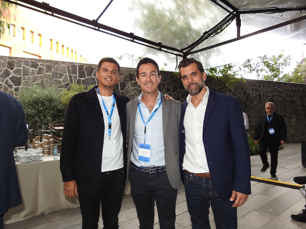 Fotografía de Pato Bichara, Vincent Speranza y un directivo aliado posando juntos bajo una carpa en el espacio de convivencia del evento Perspectives 2026.