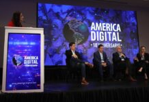 America Digital impulsa en México el debate sobre la Sexta Revolución Tecnológica con su Congreso IA 2026 Un panel de discusión sobre un escenario iluminado donde tres conferencistas hombres y una mujer debaten sentados en sillones negros. En el extremo izquierdo, una presentadora de pie en un podio blanco coordina el evento frente a una monumental pantalla LED de fondo azul con el logotipo oficial "AMERICA DIGITAL 10° ANIVERSARIO".