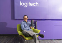 Logitech acelera la videocolaboración empresarial junto al canal en México Jorge Parra, Head de Logitech for Business México, sostiene un dispositivo de comunicación en un entorno moderno diseñado para la videocolaboración.