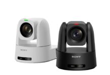 Sony apuesta por la automatización inteligente con nuevas cámaras PTZ 4K para educación, empresas y deportes Fotografía de producto en plano medio que muestra dos cámaras robóticas PTZ compactas de Sony dispuestas una al lado de la otra sobre un fondo blanco limpio. La cámara de la izquierda es de color blanco con una pequeña luz indicadora verde en la parte superior del lente, mientras que la cámara de la derecha es de color negro mate con un indicador luminoso rojo. Ambos dispositivos muestran el logotipo de "SONY" grabado en letras plateadas en la base delantera, la cual incorpora un pequeño panel inferior con luces indicadoras de encendido (POWER) y conectividad de red (NETWORK).