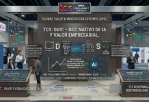 TCS lanza GVIC para impulsar centros de capacidades globales nativos de IA en empresas Fotografía en plano medio de Soumen Roy, Director de TCS GVIC, posando de frente con una expresión seria y los brazos cruzados en el interior de una oficina moderna. El ejecutivo, de rasgos del sudeste asiático y cabello corto canoso, viste un traje sastre formal de color gris oscuro, una camisa blanca de cuello rígido y una corbata de seda azul marino. El fondo de la escena se encuentra difuminado y revela un entorno corporativo con ventanales iluminados por luz natural de día.