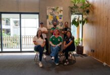 Ciberseguridad OT redefine la estrategia de Círculo Daat para proteger infraestructuras críticas Fotografía en plano general medio que muestra a seis integrantes del equipo de Círculo Daat posando juntos de manera casual en el salón iluminado. Tres mujeres están sentadas al frente en sillas minimalistas de color verde claro y patas de madera; la de la izquierda usa playera blanca, la del centro playera verde y jeans, y la de la derecha playera negra con detalles patrios. Detrás de ellas permanecen de pie tres hombres con los brazos cruzados: el de la izquierda con playera blanca y gorra azul, el del centro con playera verde de la selección y el de la derecha con playera negra y lentes, teniendo al fondo un gran ventanal corredizo de cristal que da a una terraza con barandal de madera.
