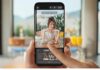 Huawei apuesta por la IA para transformar la fotografía móvil con funciones que anticipan el futuro Pantalla de un smartphone mostrando la aplicación de cámara activa. Una mujer posa sonriendo en una cafetería, mientras una silueta blanca generada por IA se superpone en la interfaz para sugerirle la mejor postura.