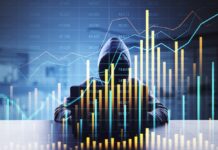 Akamai advierte que la economía del cibercrimen acelera en Latinoamérica y convierte a las API en el blanco principal de los ataques Silueta de una persona encapuchada trabajando frente a una computadora portátil en un ambiente con poca iluminación. Sobre la figura y el fondo se superponen múltiples gráficos bursátiles luminosos, líneas de tendencia fluctuantes y diagramas de barras con cifras numéricas, lo que ilustra visualmente el concepto de la rentabilidad financiera y el ecosistema económico de los ataques digitales.