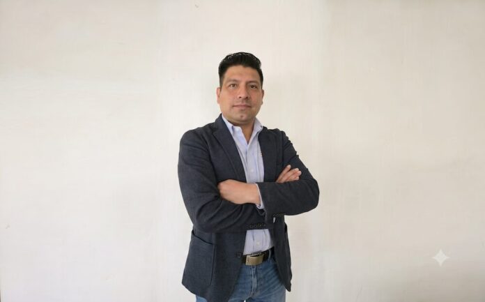 Gabriel Rivas encabeza la estrategia de posicionamiento integral y desarrollo del canal para Intellinet y Manhattan Retrato corporativo de plano medio y de frente de Gabriel Rivas, coordinador de marketing en IC Intracom. El directivo posa con los brazos cruzados ante un muro liso de fondo blanco, vistiendo un saco formal azul marino, una camisa de vestir azul claro desabrochada en el cuello y jeans. Tiene el cabello corto oscuro y peinado hacia atrás.