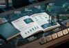 HPE acelera una infraestructura eficiente y segura para impulsar la IA responsable Composición gráfica fotorrealista sobre un escritorio oscuro que muestra elementos del "11º INFORME ANUAL LIVING PROGRESS | FY25" de Hewlett Packard Enterprise. En el centro descansa un libro abierto con gráficos estadísticos, junto a representaciones en miniatura de un rack de servidores y un centro de datos modular. Alrededor del libro flotan textos holográficos, mapas y líneas de conexión que mencionan a Siemens Energy, HPE GreenLake e Isambard-AI, junto con métricas destacadas de 96%, 87% y 72%. En la parte inferior derecha, se alinean pequeños bloques a modo de reconocimientos con los nombres de Fortune 100, CDP Climate A List, EcoVadis, Ethisphere y KnowTheChain.