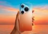 Huawei renueva su ecosistema en México con smartphones, tablet, audio y smartwatch de última generación Fotografía de una mano sosteniendo el nuevo HUAWEI Pura 90s frente a un paisaje marítimo durante el atardecer. La parte posterior del dispositivo muestra un llamativo degradado que transita de azul cielo en la parte superior a un tono naranja intenso en la inferior. En la esquina superior izquierda se aprecia un módulo de cámara fotográfica con forma de triángulo con bordes curvos que aloja tres lentes de gran tamaño.
