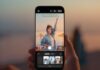 Huawei presenta la HUAWEI Pura 90s Series con IA y avances en fotografía móvil Primer plano de unas manos sosteniendo verticalmente un smartphone Huawei en exteriores durante el atardecer. La pantalla muestra la aplicación de cámara con una vista previa de composición asistida por inteligencia artificial; sobre la imagen de una mujer posando en la playa con sombrillas de fondo, se sobrepone una silueta de guía delineada con vectores blancos. En la parte inferior de la pantalla se despliega un carrusel con opciones y sugerencias de encuadre fotográfico.