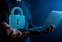 Nutanix fortalece la gobernanza de agentes de IA con mayor control de acceso y costos Ilustración conceptual de un especialista en tecnología sosteniendo una computadora portátil abierta con la mano derecha, mientras de su mano izquierda emerge un gran candado holográfico tridimensional de color azul brillante, estructurado con líneas de circuitos electrónicos y un resplandor luminoso en el centro.