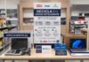Office Depot México e Intel impulsan el reciclaje electrónico con un programa de renovación tecnológica Fotografía de un módulo de exhibición promocional dentro de una tienda. Al centro, un gran cartel blanco y azul muestra el título "RECICLA EN MODO INTELIGENTE" junto a los logotipos de Office Depot, Intel y PROAMBI. A la izquierda, sobre la mesa de exhibición, hay una urna de acrílico transparente etiquetada con "DEPOSITA TUS DISPOSITIVOS AQUÍ", la cual contiene una laptop, una tablet, un celular y un control de videojuegos viejos. En el centro descansa un cupón promocional gigante de $1,500 MXN, y a la derecha se exhibe una laptop Lenovo nueva junto a cajas azules de procesadores Intel Core y un pequeño letrero informativo de PROAMBI.