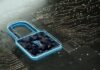 Tanium plantea una estrategia unificada para enfrentar los nuevos retos de la ciberseguridad Ilustración conceptual en 3D que muestra un candado digital translúcido brillando en tono azul neón. El cuerpo del candado está formado por secuencias de números y códigos, y se encuentra apoyado sobre una superficie oscura que simula una placa de circuito impreso con líneas metálicas y pequeños nodos luminosos.