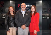 Kingston encuentra nuevas oportunidades para el canal ante los incrementos y desabasto del mercado Fotografía grupal de tres ejecutivos posando juntos en un entorno corporativo de exhibición tecnológica. De izquierda a derecha: Cristina Carbajal con chamarra negra, Oscar Martínez al centro con chamarra gris oscura, e Ivette Barragán vistiendo un traje rojo brillante, todos frente a vitrinas y pantallas de productos Kingston.