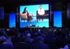SAP NOW IA Tour México impulsa la inteligencia artificial empresarial con SAP Business AI Platform Vista desde la perspectiva del público hacia el escenario principal de SAP Now, donde se proyecta en pantallas gigantes la charla entre Adriana Aroulho y el CIO de Coca-Cola FEMSA, frente a una gran audiencia.