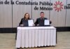 Siigo Aspel y el Colegio de Contadores fortalecen la actualización profesional Fotografía de Rosalía Ortega López y Hans L. Schmal sentados detrás de una mesa con mantel blanco, sosteniendo y mostrando a la cámara las carpetas abiertas con los documentos del convenio recién firmado.