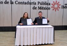 Siigo Aspel y el Colegio de Contadores fortalecen la actualización profesional Fotografía de Rosalía Ortega López y Hans L. Schmal sentados detrás de una mesa con mantel blanco, sosteniendo y mostrando a la cámara las carpetas abiertas con los documentos del convenio recién firmado.