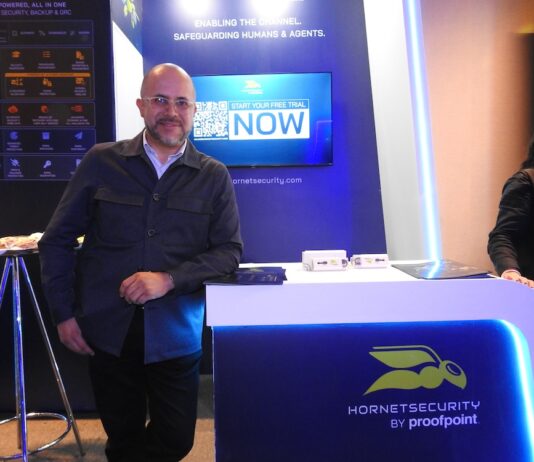 Hornetsecurity fortalece su apuesta por Latinoamérica a través del canal Fotografía de Alejandro Rodríguez, territory senior manager de Hornetsecurity, de pie frente a un stand de exhibición azul con el logotipo de Hornetsecurity by proofpoint.
