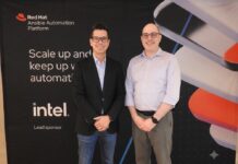 Automatización de TI con Red Hat Ansible impulsa una nueva era para las operaciones empresariales Fotografía de Daniel Romero y Chad Ferman posando de pie y sonriendo frente a un fondo negro con el logotipo de Red Hat Ansible Automation Platform y el patrocinio de Intel. Daniel viste un saco negro y jeans, mientras que Chad usa una camisa azul claro y pantalones grises.