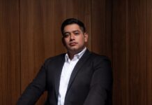 Select: ¿Quién invierte en tecnología? Gasto TIC y adopción digital por macrosector en México Fotografía de retrato corporativo en plano medio de Alan Adolfo López Arenas, analista de la consultora Select, vistiendo camisa formal y sonriendo de frente a la cámara en un entorno corporativo.