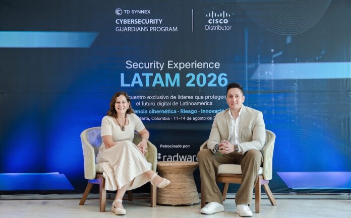 Liderazgo conjunto para la transformación del canal en ciberseguridad Fotografía de Claudia Cincotto y Uriel Sánchez sentados en sillas de diseño tejido frente a un fondo azul iluminado que promociona el evento Security Experience LATAM 2026, con los logotipos de TD SYNNEX y Cisco Distributor.