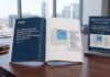 Xerox es reconocida como líder mundial en soluciones para salas de correo Fotografía de una mesa de conferencias de madera sobre la cual descansan un reporte impreso abierto y un letrero de acrílico transparente. Ambos elementos exhiben el reconocimiento de Xerox en el cuadrante de "Líderes" dentro del gráfico de IDC MarketScape de 2026. De fondo, se observan amplios ventanales con vista a edificios de la ciudad.