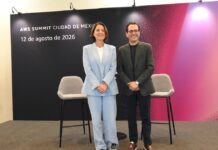 AWS Summit 2026, Ciudad de México: agentes que transforman negocios Paula Bellizia y Rubén Mugártegui de pie y sonriendo juntos en el escenario de la rueda de prensa del evento.