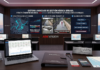 Hikvision combina radar y video para anticipar inundaciones Render de un moderno centro de monitoreo. Al fondo, una pantalla gigante ilustra el "Sistema Avanzado de Gestión Hídrica Urbana" de Hikvision con gráficos de detección de radar, visualización de canales y un flujo de prevención. En primer plano, sobre un escritorio de madera, hay una computadora portátil, un gafete corporativo y un letrero con una cita de Xavier Arroyo.