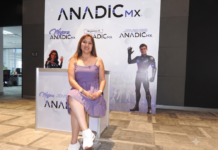 Impulso empresarial femenino 2026: Liderazgo y redes de negocio Anadic Mx Fotografía de Sonia Rodríguez Cancino sentada con las piernas cruzadas sobre un taburete alto en un pabellón de exposiciones. Viste un vestido corto de color morado claro y tenis blancos. A su espalda se observa un gran panel publicitario con el logotipo de ANADIC MX y sus comités como "Mujeres ANADIC MX" y "Jóvenes ANADIC MX", además de un pendón de "IT Leaders Hub" a la derecha.