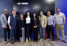 Ingram Micro y Alteryx: La alianza definitiva para democratizar el poder de los datos y la IA Fotografía grupal de ocho ejecutivos e ingenieros especialistas de Ingram Micro y Alteryx posando sonrientes en fila en una sala de eventos frente al fondo institucional de la alianza.