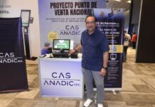 TechZone lidera la digitalización comercial y revoluciona el punto de venta Fotografía de cuerpo entero de Francisco Romero, Director General de TechZone y TechZone POS, luciendo una camisa guayabera azul marino y anteojos, de pie junto al mostrador interactivo de cobro equipado con terminal de punto de venta y frente a los carteles de CAS ANADIC y MyBusiness POS.