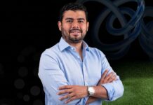 Gigas impulsa el futuro de la nube en Latinoamérica con su innovador programa de partners Fotografía de retrato de Ezequiel Sulvarán posando de tres cuartos con los brazos cruzados. Viste una camisa de manga larga color azul claro de cuello abierto y luce un reloj metálico en la muñeca izquierda, sobre un fondo digital con tonos oscuros y elementos abstractos.