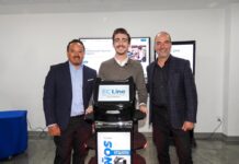 EC Line y Grupo CVA transforman la robótica comercial con modelos de servicio administrado Fotografía de tres directivos sonriendo en una sala de exhibición mientras posan rodeando un robot de servicio interactivo de EC Line. El equipo robótico, de color negro con la pantalla principal iluminada, se ubica al centro, flanqueado por pantallas táctiles corporativas en el fondo.