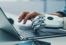 Hostinger impulsa la evolución del ecommerce en México frente al avance de la IA Fotografía de concepto tecnológico que muestra en primer plano una mano robótica articulada de color blanco escribiendo sobre el teclado de una computadora portátil plateada.