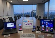 Lenovo y Motorola expanden su IA personal Qira a más dispositivos, apps y mercados Fotografía de una mesa de juntas con un panorama urbano de fondo, donde se exhibe una línea de dispositivos Lenovo y Motorola encendidos que muestran la interfaz de Qira, incluyendo una laptop, smartphones plegables y de pantalla plana, un reloj inteligente moto watch ultra y una tableta, acompañados de carteles informativos.