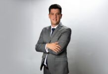 Salicru identifica nuevas oportunidades para el canal en el mercado de protección energética Fotografía de retrato de Juan Carlos Casillas, vestido con un traje gris, camisa blanca y corbata oscura. Posando de pie, con los brazos cruzados y una ligera sonrisa, frente a un fondo blanco con iluminación de estudio.