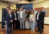 La alianza estratégica de Maps y HornetSecurity para blindar el futuro digital Fotografía de grupo que muestra a diez ejecutivos e ingenieros de MAPS Disruptivo y Hornetsecurity posando juntos en un salón con techo de vigas de madera frente a un banner publicitario de MAPS.