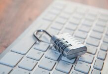 Trellix detecta 1.2 millones de ciberamenazas en México durante el primer trimestre de 2026 Fotografía en primer plano de un candado metálico de combinación numérica abierto, descansando sobre las teclas alfanuméricas de un teclado de computadora color blanco.