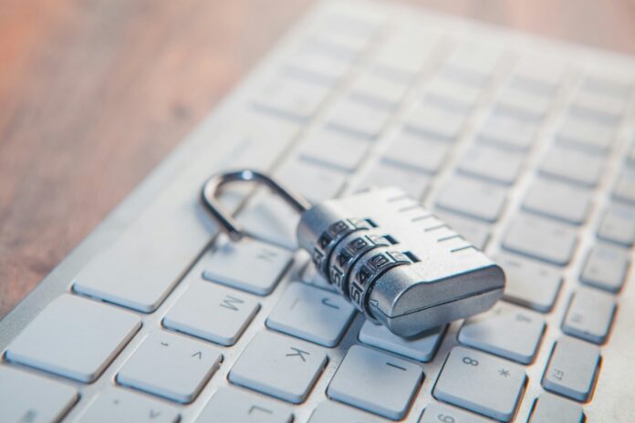 México registra 1.2 millones de detecciones de ciberamenazas en el primer trimestre de 2026 Fotografía en primer plano de un candado metálico de combinación numérica abierto, descansando sobre las teclas alfanuméricas de un teclado de computadora color blanco.