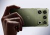 Motorola presenta el Motorola Signature 27: la nueva era de la IA ultra premium Fotografía en plano detalle sosteniendo horizontalmente un smartphone motorola signature 27 en acabado PANTONE Capulet Olive con textura textil cepillada, mostrando la insignia icónica de Motorola y el módulo de cámaras con el grabado "Audio by B&O" e lentes de sensor de alta resolución.