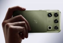Motorola presenta el Motorola Signature 27: la nueva era de la IA ultra premium Fotografía en plano detalle sosteniendo horizontalmente un smartphone motorola signature 27 en acabado PANTONE Capulet Olive con textura textil cepillada, mostrando la insignia icónica de Motorola y el módulo de cámaras con el grabado "Audio by B&O" e lentes de sensor de alta resolución.