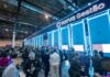 Universo TOTVS 2026 impulsará la IA aplicada y los negocios en Latinoamérica Fotografía en ángulo panorámico de la concurrida área de exhibición tecnológica en Universo TOTVS, iluminada con letreros neón azules donde destaca la marca "TOTVS Gestão" e interactivos de consulta divididos en módulos numerados para sectores como salud y logística.