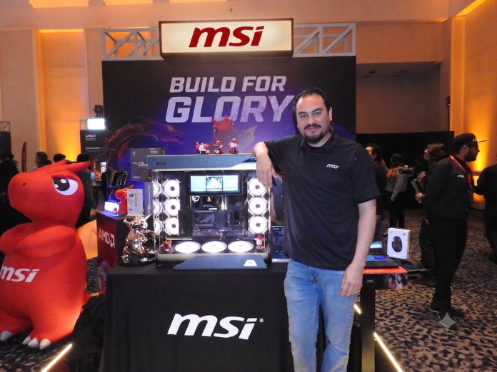 Yaid Ali Nahle presenta la línea premium MEG de MSI para entusiastas del hardware en México Fotografía en plano medio de Yaid Ali Nahle, Territory Manager para MSI México, apoyado sonriente sobre el gabinete Maestro 900 con iluminación RGB en el estand corporativo