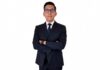 Enlace Team evoluciona su Marketplace B2B para acelerar los negocios de sus canales Fotografía de retrato en plano medio de Alberto Montiel, Gerente de Marketplace en TEAM, vistiendo traje ejecutivo azul marino con corbata a juego y anteojos, posando con los brazos cruzados frente a un fondo blanco.
