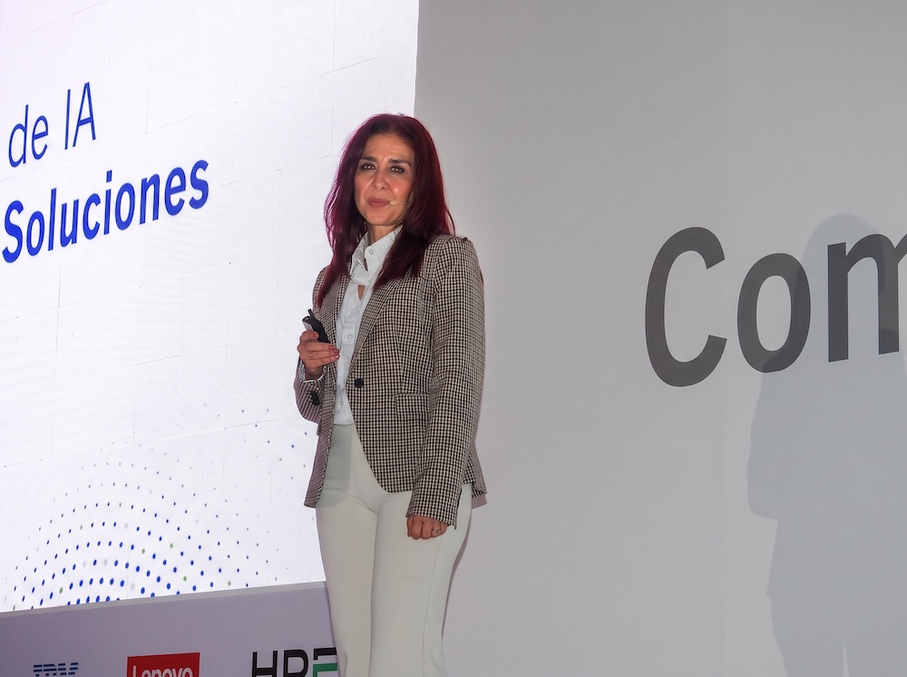 Fotografía de retrato en plano medio de Ana María Arreola, Directora General de CompuSoluciones, vistiendo traje ejecutivo en tono claro, sentada sonriente en una sala de recepción corporativa.