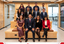 Canon Mexicana y Avance consolidan alianza para liderar el mercado de impresión de gran formato en México Fotografía grupal corporativa que muestra a directivos y colaboradores de Canon Mexicana y Avance y Tecnología en Plásticos sonriendo y distribuidos en gradas de madera en el interior del nuevo showroom, con el logotipo de Canon enmarcado en una franja roja y blanca en la parte inferior.