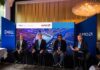 Innovación y ciberresiliencia en el nuevo ecosistema digital junto a Dell Technologies, AMD y CISO Club Fotografía en plano general de cuatro panelistas sentados en un escenario frente a una gran pantalla azul de Dell Technologies y AMD, participando en un panel ante mesas de invitados.