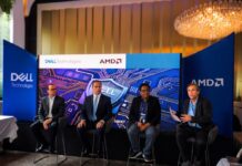 Innovación y ciberresiliencia en el nuevo ecosistema digital junto a Dell Technologies, AMD y CISO Club Fotografía en plano general de cuatro panelistas sentados en un escenario frente a una gran pantalla azul de Dell Technologies y AMD, participando en un panel ante mesas de invitados.