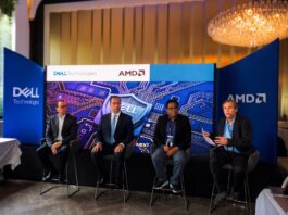 Innovación y ciberresiliencia en el nuevo ecosistema digital junto a Dell Technologies, AMD y CISO Club Fotografía en plano general de cuatro panelistas sentados en un escenario frente a una gran pantalla azul de Dell Technologies y AMD, participando en un panel ante mesas de invitados.